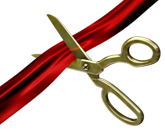 gold scissors cutting a red ribbon